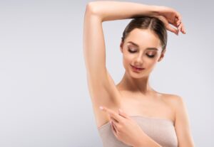 Woman holding up arm showing smooth underarm from laser hair removal in East Bay
