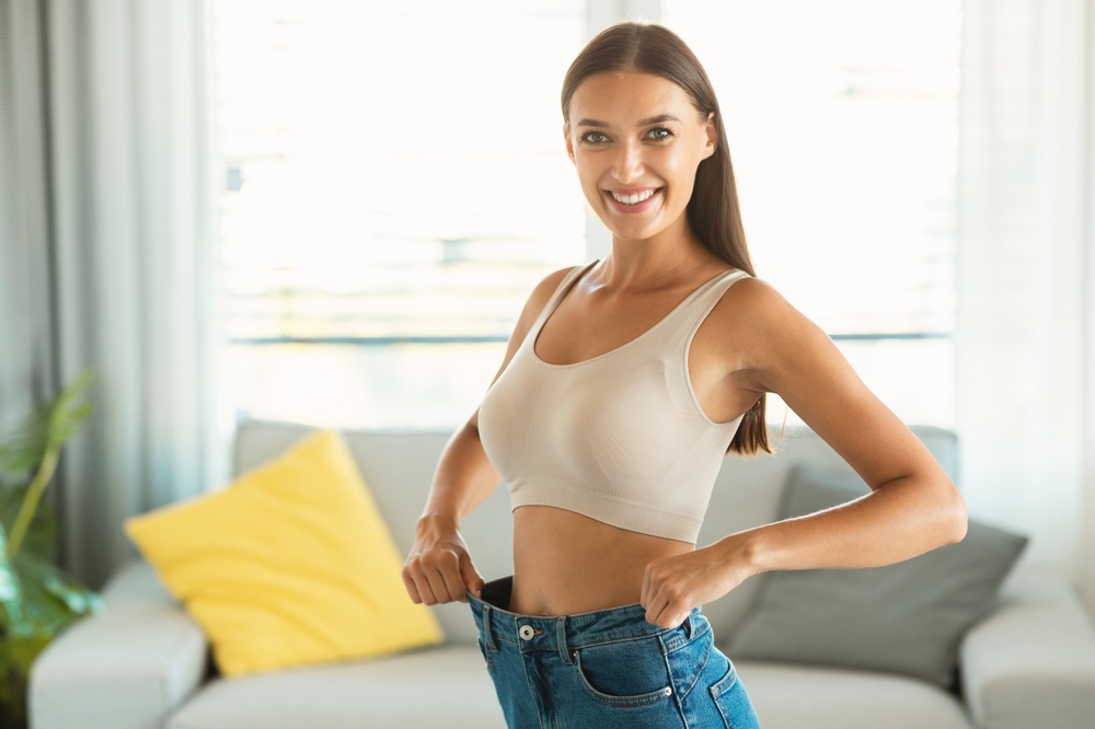 Woman smiling wearing jeans too big to show weight loss with Semaglutide in East Bay, CA