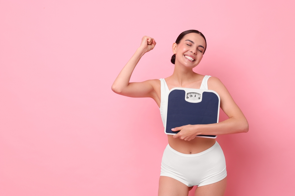 Woman holding a scale and celebrating her weight loss with Tirzepatide in Livermore